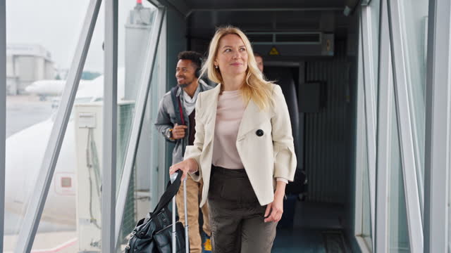 Blond Woman and Two Men Disembarking an Airplane