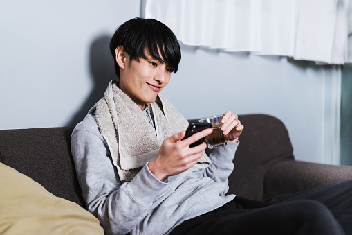 A Japanese man in his thirties who operates a smartphone in the room after the shower