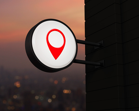 Map pin point location icon on hanging black rounded signboard over blur of cityscape on warm light sundown, Map pointer navigation concept, 3D rendering