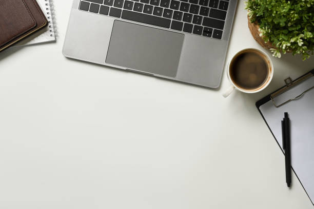 istock Modern white office desk table with laptop computer, cup of coffee and notebook. Top view with copy space, flat lay 1485025131