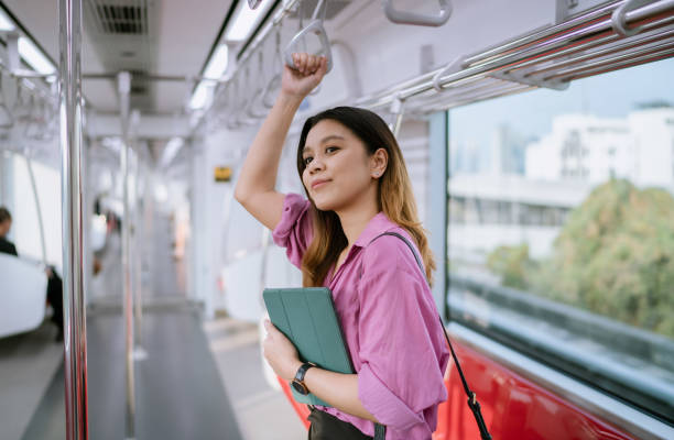 Asian Woman Preparing to Get off Rapid Transit as It's Approaching the Station.