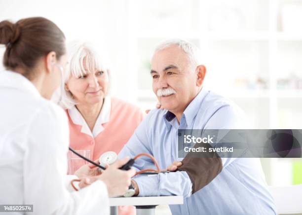 Senior Couple At Doctors Office Stock Photo - Download Image Now - Blood Pressure Gauge, Hospital, Mature Women