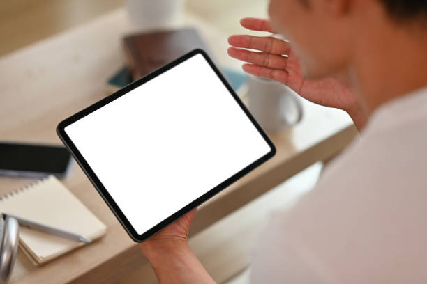 istock Cropped image of man using digital tablet in living room. White empty screen for montage your graphic display. 1485028761