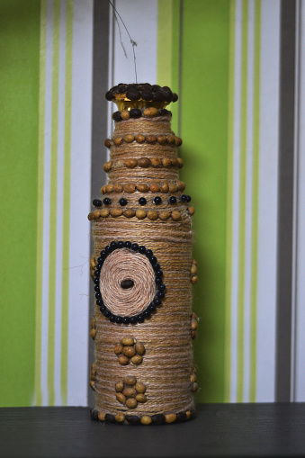 The jar is made by hand, against the background of a green wall