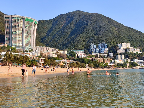 People sunbathing on Repulse Bay beach, on Hong Kong island South coast idyllic bay.
