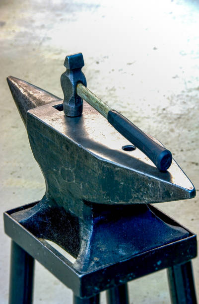 Anvil and a hammer on an industrial background stock photo