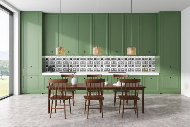 istock Stylish kitchen interior with eating table and chairs, cooking area and window 1485037849