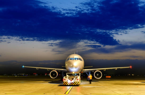 日没時に暴走する飛行機 夜の民間飛行機。正面図、上からの黒いコピーアンドペースト - on wheels 写真 ストックフォトと画像