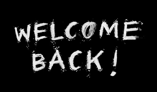 WELCOME BACK text written by hand and dry  white pastel on black background. Messy, dirty letters with uneven edges with scattered crumbs of white chalk. 
VECTOR FILE - enlarge without lost the quality! Zoom to see amazing details!