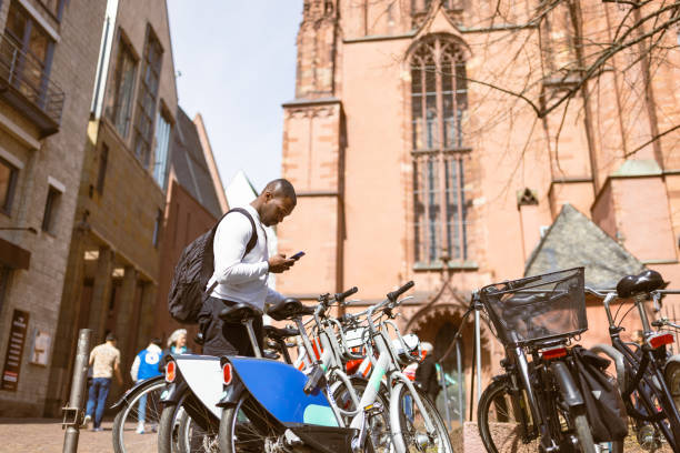 Casually Dressed Black Tourist in Frankfurt Renting a City Bike stock photo