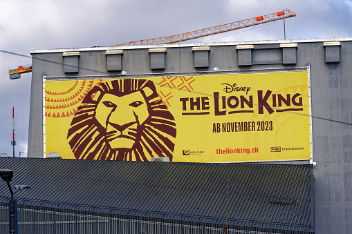 Lion King musical advertising banner at facade of theater named Theater 11 at City of Zürich district Oerlikon on a spring morning. Photo taken April 4th, 2023, Zurich, Switzerland.