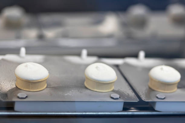 istock Icecream automatic production line - conveyor belt with ice cream cones at modern food processing factory. Food dairy industry, manufacturing, engineering and automated technology equipment concept 1485043376