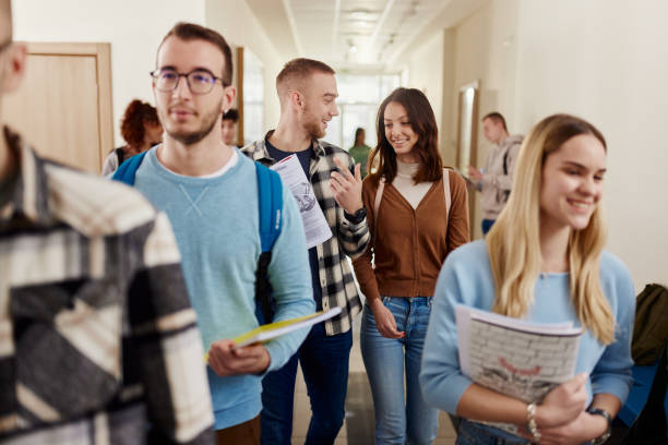 istock Happy college couple talking on the move in a hallway. 1485045449