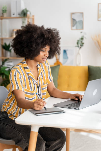 istock Smiling black woman working on laptop 1485048105