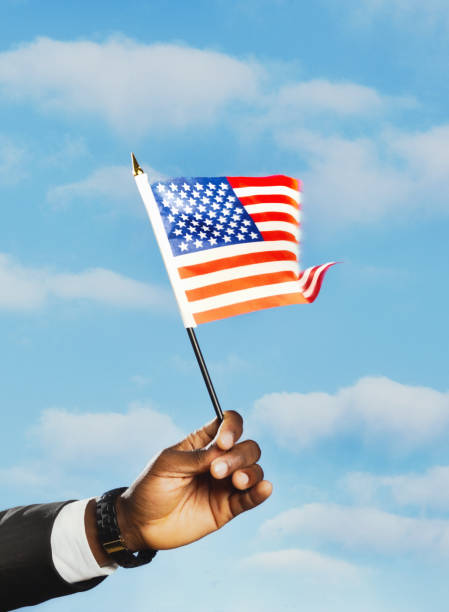 istock Well dressed man's hand holding the US flag 1485048399
