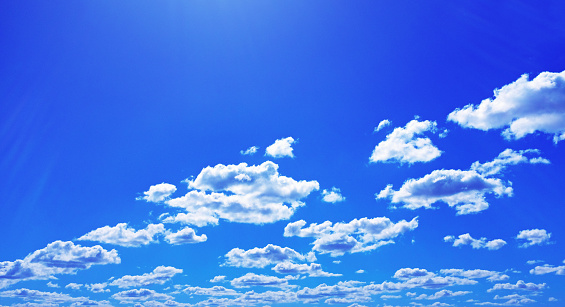 Scattered cumulus clouds in a deep blue sunny summer sky, with copy space