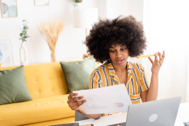 istock Smiling black woman using laptop at home 1485050532