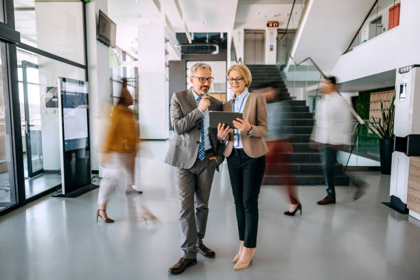 istock Coworkers discussing work with people in blurred motion behind them 1485050572