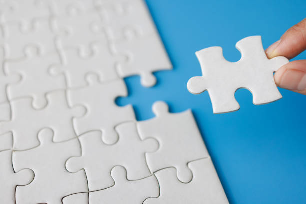 istock Closeup hand  connecting jigsaw puzzle with sunlight effect, Business solutions, success and strategy concept 1485050670