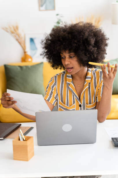 istock Smiling black woman using laptop at home 1485050696