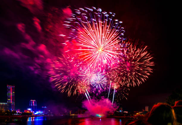 fireworks over the pond in the big city, silhouettes of people on the beach - central america flash imagens e fotografias de stock