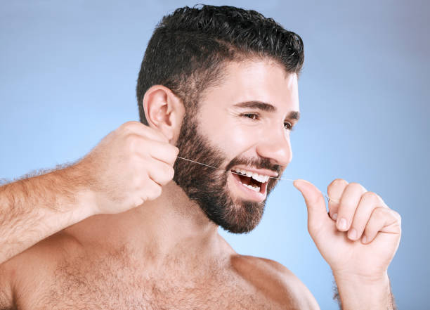 구강, 치실 및 치과 위생은 건강한 잇몸을 위해 치아를 청소하는 파란색 배경에 스튜디오에 있는 한 남자와 함께합니다. 치과 의사, 의료 및 젊은 남성이 치석이나 치은염을 제거하기 위해 치실� - candy make up chewing gum blue 뉴스 사진 이미지