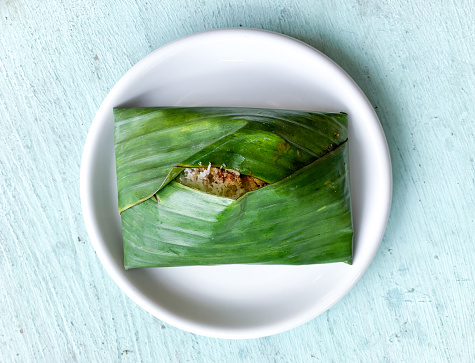 Traditional food Makassar, South Sulawesi called Sokko or Songkolo (Nasi Ketan). Made from sticky rice with toppings anchovy, grated coconut and spicy sambal wrapped in banana leaf.