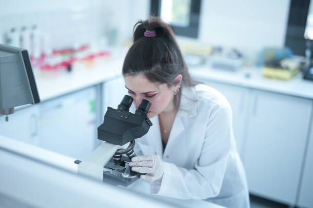 istock A young female biochemist looking at a microscope during research 1485069372