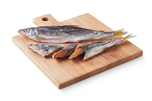 Photo of Dried fish on a board and on a white background