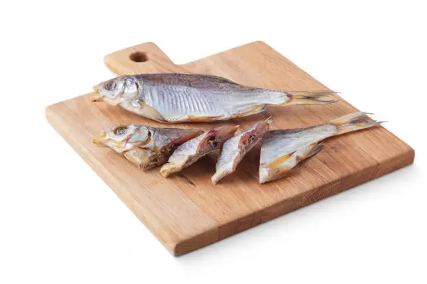 Photo of Dried fish on a board and on a white background