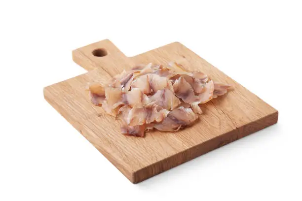 Photo of Dried fish fillets on a board and on a white background