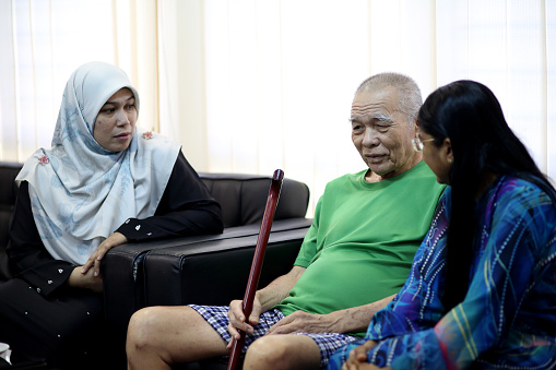 Asian senior man is chatting with Indian and Muslim women during Hari Raya gathering