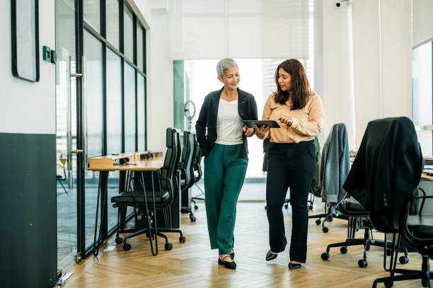 frauen unterschiedlicher ethnien arbeiten in einem modernen büro zusammen - indian ethnicity meeting business person business stock-fotos und bilder