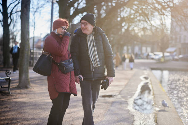 istock Senior couple laughing while walking along a river footpath in winter 1485079327