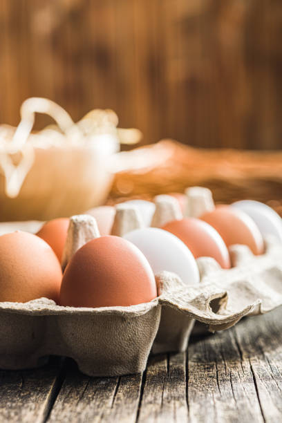istock Whole chicken eggs in eggbox on wooden table. 1485082535