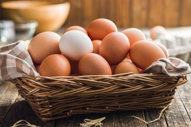 istock Whole chicken eggs in basket on wooden table. 1485082774