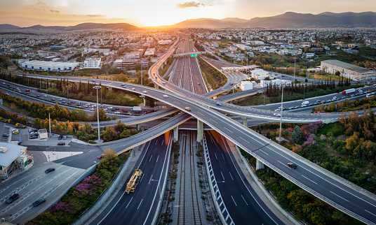 Aerial panoramic view of multilevel junction highway road as seen in Attiki Odos toll road motorway, Athens, Greece, during golden sunset time