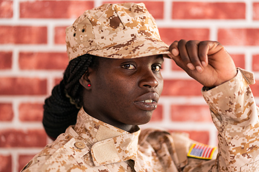Portrait of serious young female soldier in military uniform