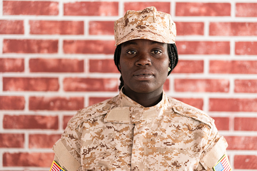 Portrait of serious young female soldier in military uniform