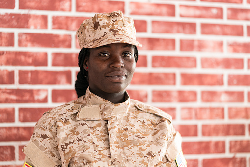 Portrait of serious young female soldier in military uniform