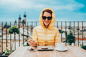 Happy woman eating dessert with coffee on rooftop
