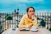 Depressed woman eating dessert with coffee on rooftop cafe
