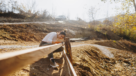 Photo of a young woman making a yard fence