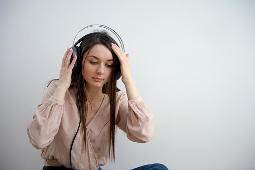 Girl in black headphones listening to music. Music lover woman is enjoying with headset. High quality photo