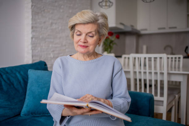 istock Woman reading book at home 1485089671