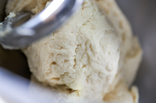 A kitchen machine is mixing dough