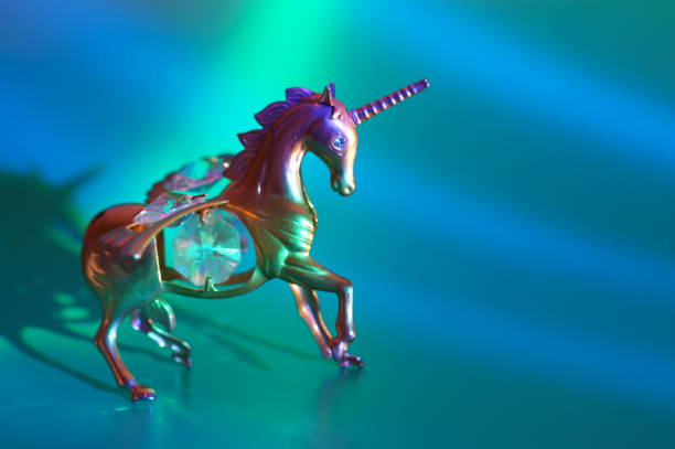 Metal unicorn figurine on a blue background.