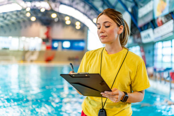 istock Smiling swim coach holding clipboard at poolside 1485093154