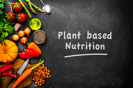 Overhead view of healthy colorful vegetables arranged at the left of a dark background.  The text \