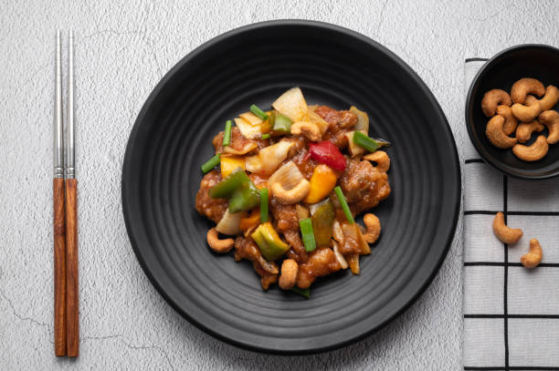 istock Stir fried chicken with cashew nuts in black dish on concrete table. 1485108800